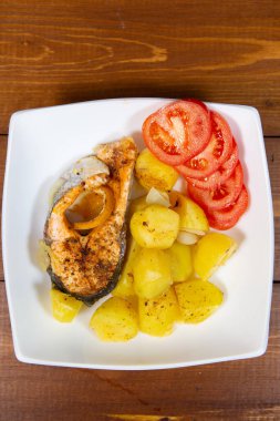 Kızarmış patates ve domatesli kızarmış balık. Yukarıdan yakın çekim görünümü