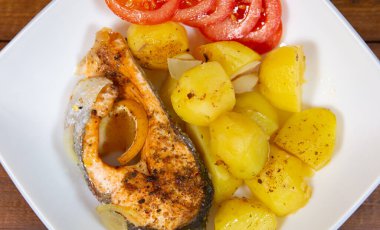 Kızarmış patates ve domatesli kızarmış balık. Yukarıdan yakın çekim görünümü