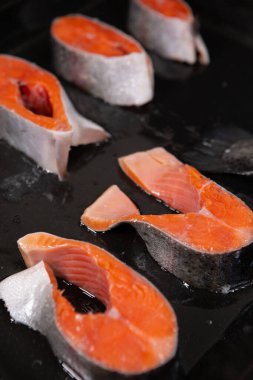 Fırında pişirmeden önce tepside taze alabalık dilimleri. Yakın plan fotoğraf.