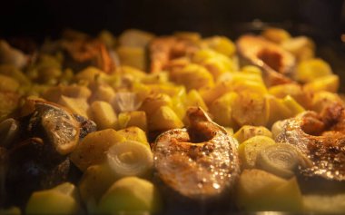 Alabalık parçaları bir tabak sebze ve baharatla fırında pişirilir. Sağlıklı sebzeli lezzetli balık.