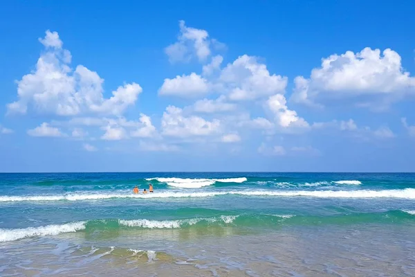 Vacationers bathe and swim in the waves of the Mediterranean Sea.