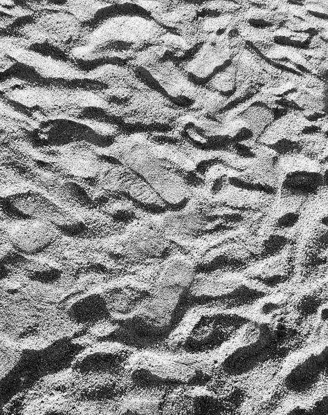 Bakgrund av grov sand på stranden täckt med spår — Stockfoto