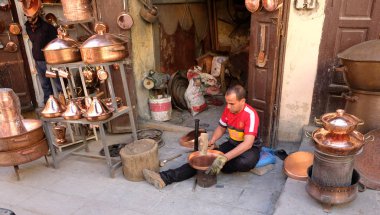 Fas, Fès şehir, 12 Mart 2019: Tinker bakırcı şehir alışveriş caddelerinden birinde onun atölye onun çalışmalarını ve onun mal gösterir.