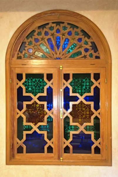 12 March 2019, Marracesh Morocco: Window with a wooden lacquered frame with a glazed mosaic of multicolored glass pieces and a copper latch — Stock Photo, Image