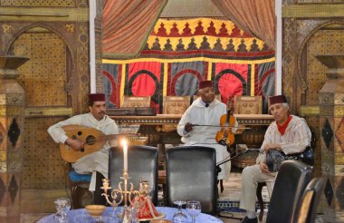 Fas - Mart 2019. Ulusal kıyafetli müzisyenlerden oluşan bir folklor topluluğu bir restoranda geleneksel müzik ve şarkılar icra ediyor.