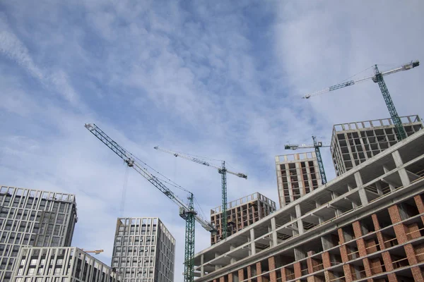 High-rise multi-storey buildings under construction. Tower cranes near building. Activity, architecture, development process, skyscraper