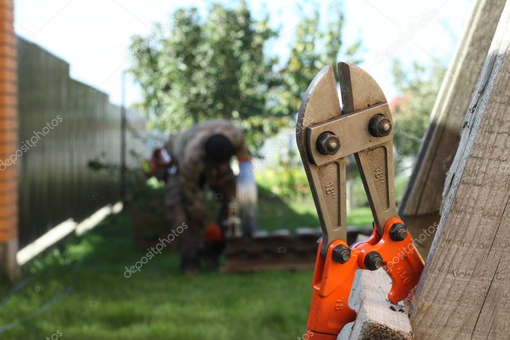 Bolt cutter on grass background. Tool, technology