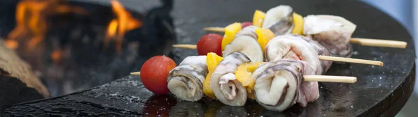 Fast food. Outdoor cooking. Yellow bell peppers, tomatoes and chili pepper are cooked on a hot grill surface with an open flame