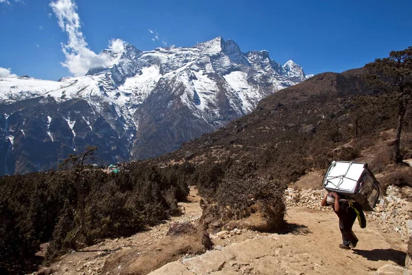 Nepalese porter carrying a heavy load to the pass in Sagarmatha National Park, Himalayas — Stock Image Nepalese Porter Carrying Heavy Load Pass Sagarmatha National Park Himalayas Royalty Free Stock Photos