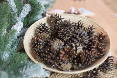 Hafif ahşap arka plan üzerinde Noel dekorasyonu. Noel tatil ağacı süslemeleri ile. Noel arka plan dekore edilmiş koni