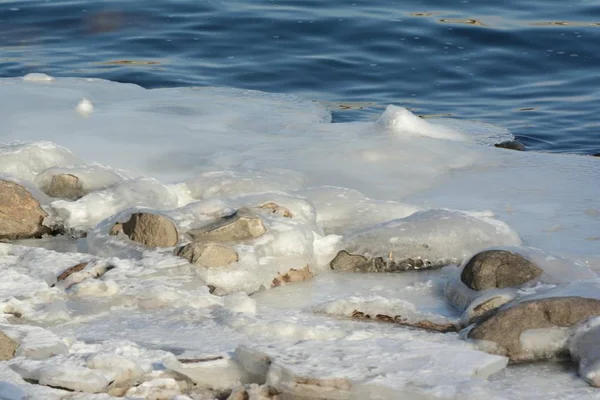 在明尼苏达州中部风景秀丽的密西西比河上游的海岸线上 冰雪中嵌入的岩石上的明亮冬季景象 — 图库照片