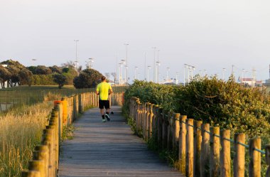 Bir adam bir yol üzerinde açık bir gün sonunda üzerinde çalışır..