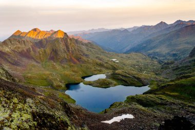 Bir gölün ortasında dağlar, gündoğumu panoramik manzaralı.