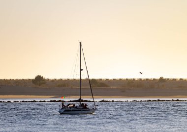 Gece karanlığında nehir boyunca Portekiz bayrağı ile bir yelkenli yelken.