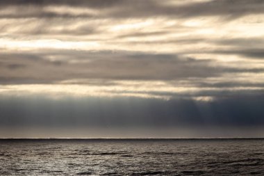 Güneş ışınları ile fırtınalı bir günde, bulutlar yakınındaki okyanus.