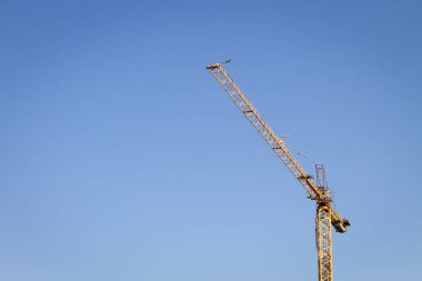 Sarı vinç açık mavi gökyüzü arka plan üzerinde. Kopya alanı.