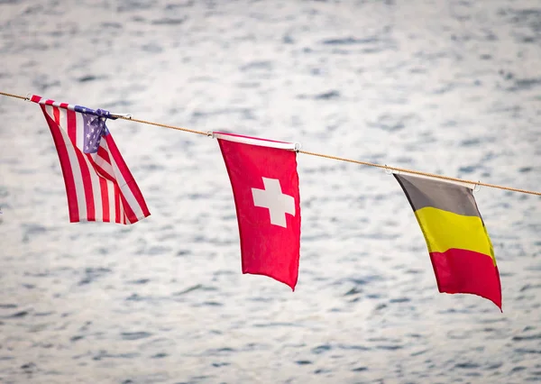背景中的一面旗帜向一条河飘扬 美利坚合众国 比利时 — 图库照片
