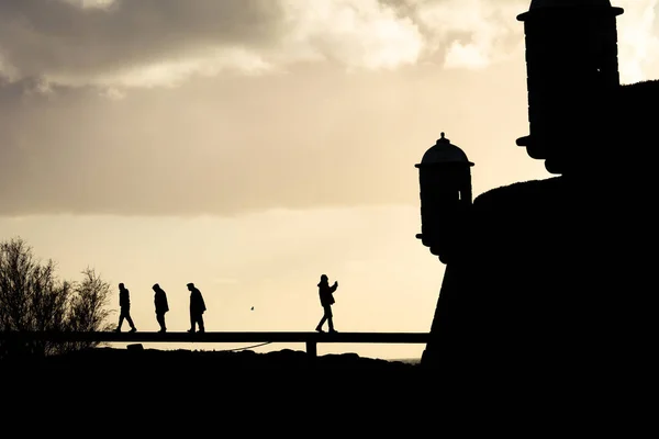 Silhouette Von Mehreren Menschen Die Von Einem Leuchtturm Weggehen Während — Stockfoto