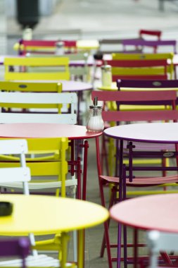 Renkli sandalyeler ve masalar terasında bir bar