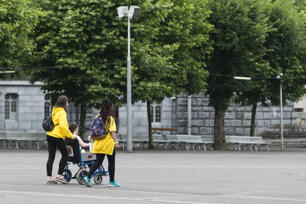 Lourdes Frankreich Juli 2016 Zwei Freiwillige Schieben Einen Rollstuhl Mit — Stockfoto