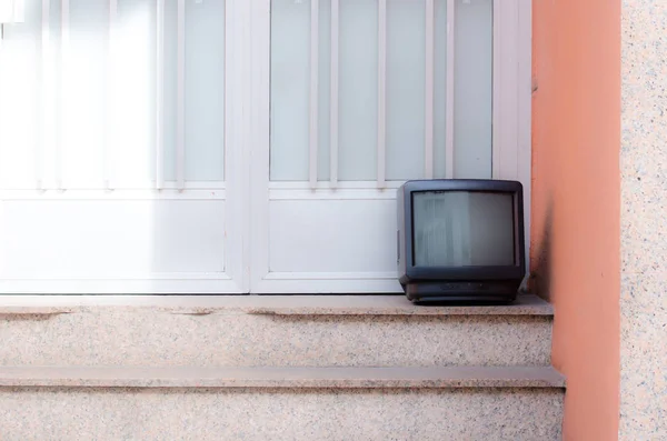 在阳光下的楼梯上的旧电视 — 图库照片