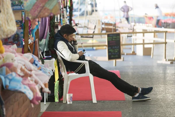 Lavoratore Del Mercato Strada Seduto Sulla Sedia Guardando Telefono — Foto Stock