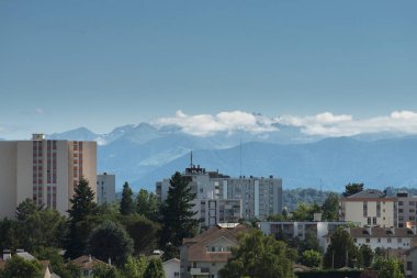 Konut binalar ve ağaçlar uzak dağlar ve mavi gökyüzü ile