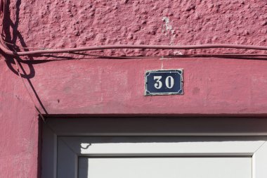 Kırmızı bina cephe üzerinde 30 sayı işareti