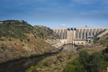 Baraj duvarı nehir ve tepelerde güneş ışığı ile