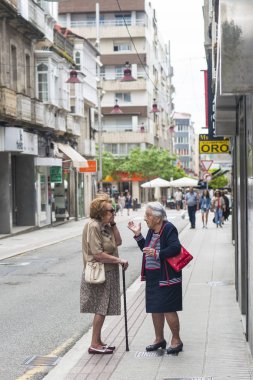 Pontevedra, İspanya - 11 Haziran 2017: İki yaşlı kadın sokağın ortasında sohbet ediyor.