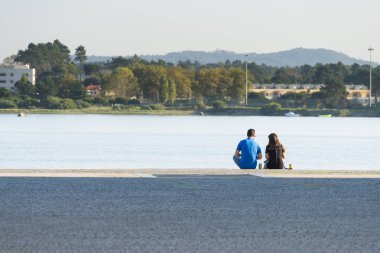 Nehir kıyısındaki parkta yürüyen insanlar