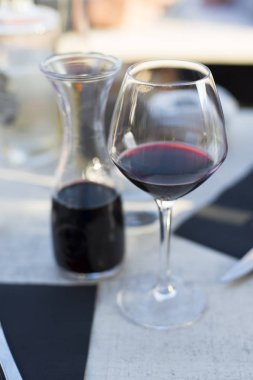Bir restoranda bir cam sürahi yanında kırmızı şarap ile Fincan