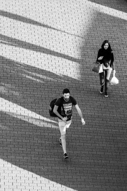 Toulouse, Fransa - 18 Nisan 2017: Şafak güneşiyle aydınlanan genç bir kadın ve erkek yürüyor.
