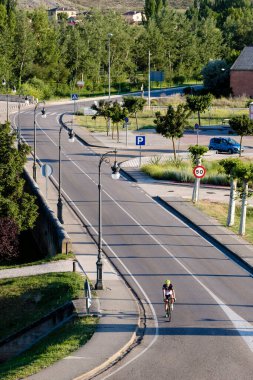 BURGO de OSMA, İspanya - 21 Haziran 2018: Bir bisikletçi köyün varoşlarındaki caddelerden birinde bisiklet pratiği yapıyor.