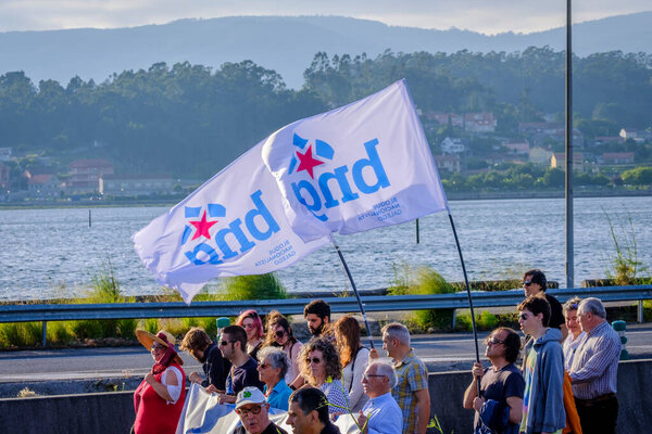ПОНТЕВЕДРА, Испания - 16 июня 2018 года: Демонстрация против перманентности целлюлозно-бумажной промышленности в прибрежной зоне деревни, в Риа-де-Понтеведра.