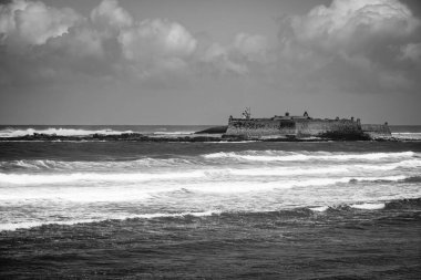 Portekiz 'deki Moledo plajının önündeki terk edilmiş askeri kalenin görüntüsü.