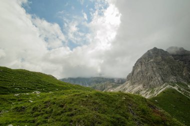 gür yeşilliklerle kaplı dağ tepe üzerinde bulutlu gökyüzü
