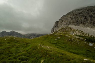gür yeşilliklerle kaplı dağ tepe üzerinde bulutlu gökyüzü
