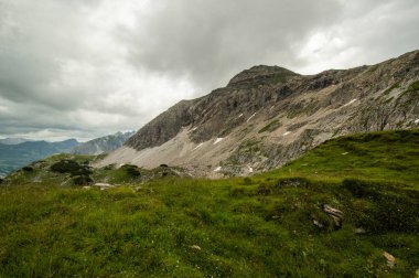 gür yeşilliklerle kaplı dağ tepe üzerinde bulutlu gökyüzü