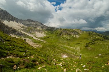 yeşil dağlık manzara ile uzak uzun yürüyüşe çıkan kimse