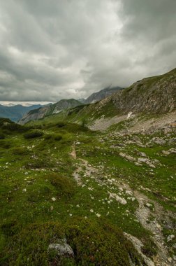 gür yeşilliklerle kaplı dağ tepe üzerinde bulutlu gökyüzü