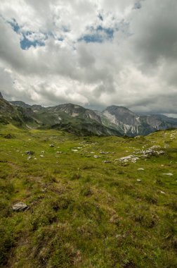 gür yeşilliklerle kaplı dağ tepe üzerinde bulutlu gökyüzü