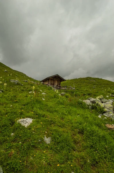 Drewniane Chaty Zielonym Wzgórzu Pochmurne Niebo — Zdjęcie stockowe