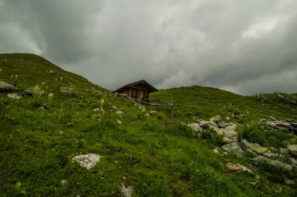 Holzhütte Auf Grünem Hügel Unter Bewölktem Himmel — Stockfoto