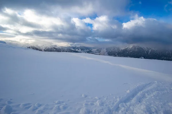 雪覆盖的山顶与遥远的山脉和多云的天空 — 图库照片