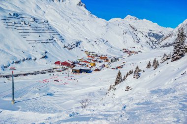 karla kaplı sahnede küçük evler ile dağlık köy