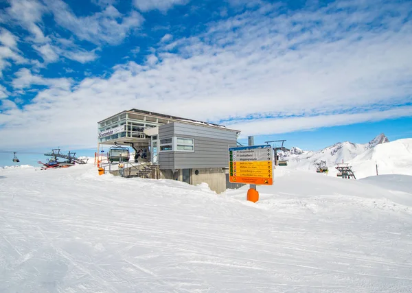 ski resort scene with building, cableway, snowy slope and blue sky