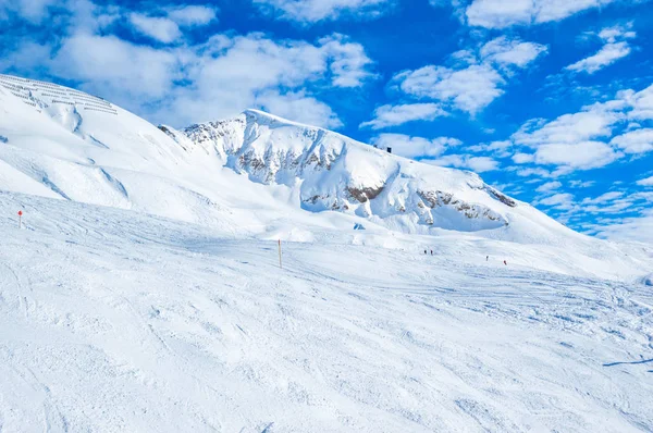 雪覆盖的山脉与滑雪道在明亮的阳光下 — 图库照片