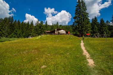 kafe ve yürüyüş insanlar ile mount resort bakyard, mavi bulutlu gökyüzü altında yemyeşil