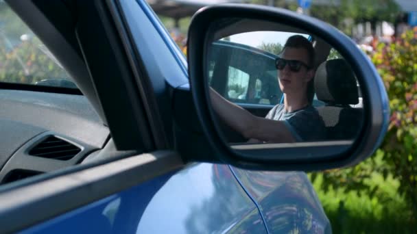 Auto side view mirror gericht vaststelling op een parkeerplaats kopen een tienerbestuurder — Stockvideo